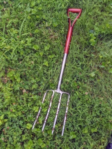 A pitchfork is an agricultural tool with a long handle and two to five tines at the end. It is used to lift and pitch or throw loose material. We also use it to harvest our garlic and onions.