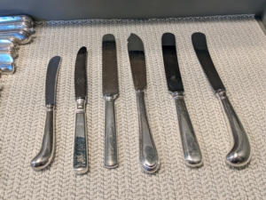 There are so many different types of knives. Look at this sampling - all the handles are different and can be flat, hollow, or solid. The blades are also very different - sometimes beautifully engraved. And the size may vary by as much as an inch or two between patterns. Do you know... knives were the first pieces of flatware used at the table? In fact, knives, or pointed personal “weapons," sometimes became the source of many dangerous and violent meal gatherings. In 1669, King Louis XIV of France banned pointed knives at the table in an effort to curtail violence. In the 1700s, the blunt-ended table knife became much more popular. Knives and various spades were made for cutting and spreading - for cutting fish, poultry, fruits, desserts, and butter. And there were special knives for using only at lunch, and some only at dinner.