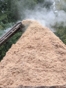 A continuous discharge conveyor carries the material away from the machine and piles it up in a mound. As the tub spins, friction actually causes some of the wood to smoke. The wood chips are put through the grinder a second time to make it even finer.