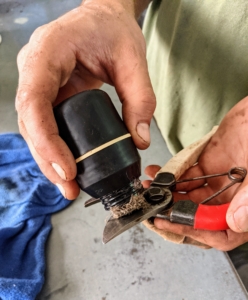 Brian lightly lubricates all the clean, sharpened metal parts. Oil will help the pruners perform more smoothly.