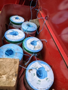 Large rolls of twine are positioned and tied to each other, so they can feed into the baler and secure the hay just before it shoots out into the trailer. There are three choices of materials to wrap bales – twine, net wrap, or plastic wrap. If properly baled and stored, hay can last a long time without degrading in quality.