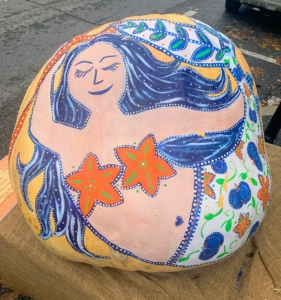 While other artists rely on the pumpkins' shapes to inspire their painted creations. This colorful mermaid was painted on a 1034 pound pumpkin.