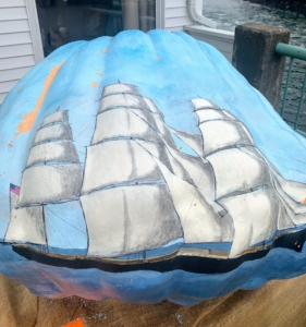 This pumpkin was decorated with an extreme clipper called the Flying Scud. The ship was painted on the surface of a 412 pound pumpkin. The Flying Scud was built in 1853 at the Metcalf and Norris Shipyard, one of the many shipyards that once prospered in the Damariscotta River area.