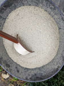 The two are mixed together in a large trug bucket and then sprinkled over the holes.