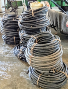 In fall, the hoses are gathered, drained, recoiled, tied, and then stored away for the season.