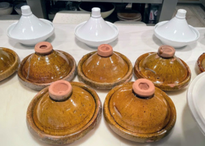 These domed dishes are Moroccan tagines. The base is wide and shallow, and the tall lid fits snugly inside the rim. As the food cooks, steam rises into the cone, condenses, and then trickles down the sides back into the dish.