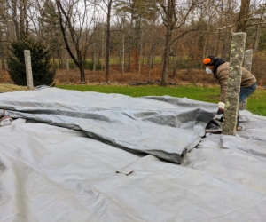 Phurba and Brian put down another tarp, overlapping it slightly with the first one and making sure it all looks neat, tidy, and covered.