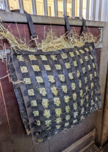 To help keep eating under control, we use hay nets specially designed to slow feed times, curb boredom, and simulate grazing. This large NibbleNet is for the donkeys. Each one holds a sizable amount of hay, but because the donkeys have to pull the hay out through the webbing, they won't eat as fast, or as much.