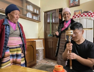 Mingmar bought a prayer wheel for his grandmother. It signifies peace of mind and is a popular gift from the young to their elder relatives. These prayer wheels are on spindles made from metal, wood, stone, leather, or coarse cotton.