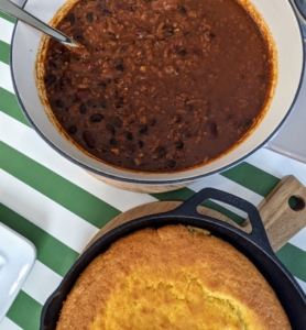 While the chili is cooking, make the cornbread in a cast iron skillet and bake until golden and risen.