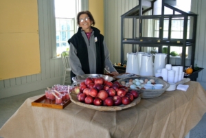 Here is Laura serving homemade applesauce, eggs, apples, and warm apple cider.