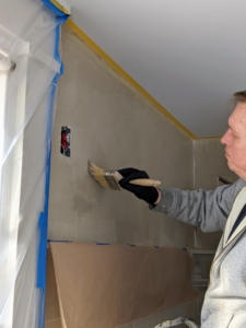 Stephan applies a very light first coat of limewash to the wall. Limewash should be applied in several thin coats using a long-haired or masonry paintbrush that creates feathered strokes.