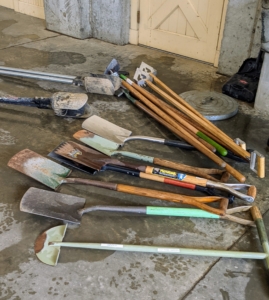 All the tools are brought to the sink for cleaning. Here are some of the spades and shovels. Do you know the difference between a shovel and a spade? Shovels are broad-bottomed tools for moving loose materials, while spades tend to have a flat bottom edge for digging.