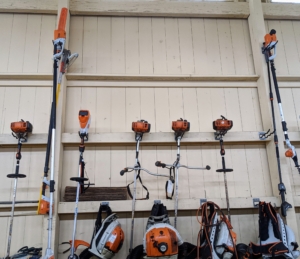 On this section of wall, we hang all the leaf blowers and weed-whackers, or string trimmers. Our blowers are made by STIHL. We’ve been using STIHL’s backpack blowers for years here at my farm. These blowers are powerful and fuel-efficient. The gasoline-powered engines provide enough rugged power to tackle heavy debris while delivering much lower emissions. The long handled tools are STIHL's telescoping pole pruners. These come in very handy and are extremely lightweight. Plus, with an adjustable shaft, the telescoping pole pruner can cut branches up to 16 feet above the ground.
