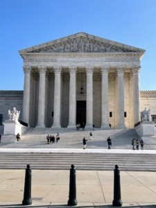 If one looks closely, one can read the engraving above the front entrance of the United States Supreme Court building. It reads "Equal Justice Under Law."
