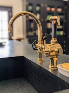 This brass fixture coordinates perfectly with the brass hardware on all the cabinetry. The black accents also match the rest of this kitchen.