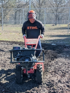 As Phurba moves, he makes sure to overlap his passes slightly, so every bit of soil is covered. Tilling also helps to level the ground as it turns over the soil. Phurba is also wearing proper safety gear – long pants, closed shoes, and head and face protection.