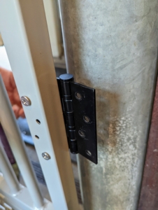 My property manager, Doug White, installed the hinges to the gates and then marked where they would be installed on the existing gate posts. These gates will not interfere with the existing wood and metal ones.