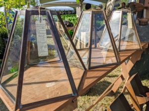 Some of the vendors were from other states. Hoffman & Woodward is located in East Berlin, Pennsylvania. They displayed many interesting and more utilitarian objects for the home and garden, such as these copper and glass cloches. A cloche is a covering for protecting plants from cold temperatures.