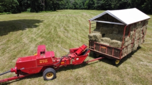 The hay is lifted by tines in the baler’s reel and then propelled into the wagon by a mechanical arm called a thrower or a kicker.