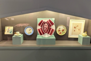 Here from left to right: "Tile Palette" by an unknown maker used by Jane Armstrong Tucker and Celia Thaxter/Haviland & Co., "Teacup and Saucer," Jane Armstrong Tucker/Haviland & Co., "Plate," Judy Chicago, "Virginia Wolf Test Plate #1 for The Dinner Party," Emily Cole, "Monarda Cabinet Plate," "Untitled (Strawberries)," and Emily Cole's "Cream Pitcher."