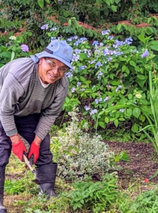 Dawa is weeding the perennial garden across from the chicken coops - it's all hands on deck for this special gathering.