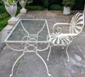 Nearby is another Sunburst chair sitting behind a small glass covered metal desk looking out at the formal sunken garden. These chairs were made in both France and the United States until the 1940s. They have a spring mechanism on the seat and backs.