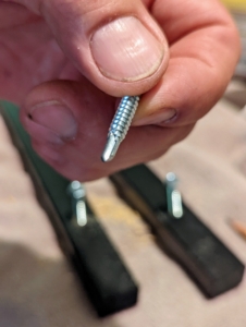 For one side, which is a metal cabinet, Doug uses self-drilling screws which can go through the metal without needed a separate drilling step.