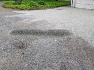 Another mound of gravel was dropped on the other side of the driveway. This is just an added layer of gravel for maintenance. When creating a new gravel driveway, the space should be filled with at least six to eight inches of crushed stone on top of stone dust. To calculate how much is needed for a specific driveway, multiply the width by the length by the depth in yards to find the cubic yards of gravel.
