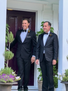 The handsome grooms - Anthony Bellomo and Christopher Spitzmiller - emerging from the house wearing boutonnieres of Dahlia 'Verrone's Obsidian.'