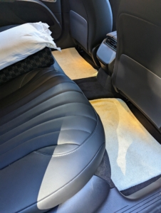 The back is also very roomy, with wireless charging areas for phones. On the back seat, I like to have a couple of pillows and a good car blanket – just in case…