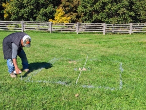 Next, he spray paints the new foot print on the grass. The new area is about nine feet by seven feet.