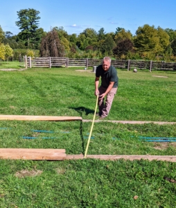 Here's my property manager, Doug White, positioning and measuring the wooden boards on which the shed will slide when it is moved.
