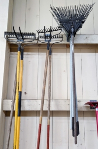 We also have hard bow rakes and soft rakes. Bow rakes have a number of other names as well, including level heads, soil rakes, and ground rakes. These rakes consist of a long head that is straight with stiff, short tines that are very rigid and don't bend or flex. They are ideal for making planting rows and breaking up hard clumps of soil. We also use them to shape our raised garden beds. A soft rake or leaf rake is a lightweight rake that is shaped like a fan with flat, springy tines radiating outward. This type of rake is designed to be light enough to glide over grass without damaging it.
