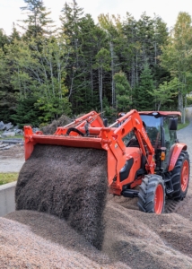 The entire process of picking up all the granite from the carriage roads and storing it neatly takes a few days. Here, the bucket is able to lift hundreds of pounds of stone at a time...