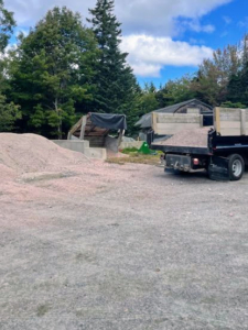 The gravel is scooped up and placed into the dump truck and then delivered to the pink gravel storage pile. In spring, the pink gravel will be sifted, washed and then laid down on the roads once again.