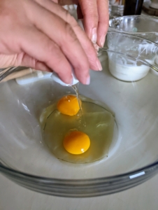 In a mixing bowl, she combines three large eggs with the mascarpone.
