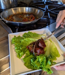 The lettuce leaves are positioned in one layer on a plate. Here, Elvira puts three meatballs on each lettuce leaf.