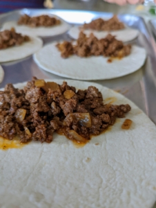 ... And then spoons about three tablespoons of the beef and onions mixture onto one end of each tortilla.
