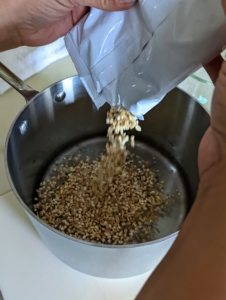 While the oven is preheating to 425-degrees Fahrenheit, Elvira prepares the grains combining the 5-grain blend, water, and a teaspoon of salt in a saucepan and cooking for about 15 to 17 minutes.