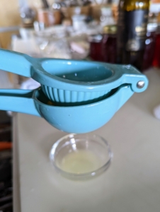 She juices one lemon into a small bowl. Here she is using my citrus press from Macy's - I love this tool because it gets every drop of juice from the fruit with just a squeeze of the handles.