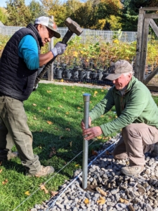Here, Pete and Doug my property manager begin hammering the first of many base posts. The removable metal cap at the top of the base post protects the hollow pipe while being pounded.