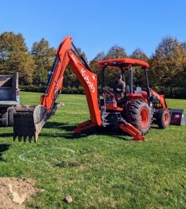 Meanwhile, my outdoor grounds crew foreman, Chhiring, begins to make the holes for the trees. He is using our dependable M4-071 tractor and backhoe. This tractor is one of the most important pieces of equipment here at the farm. It is used every day to do a myriad of jobs.
