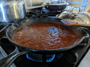 In the same skillet, Enma prepares the mild red chili sauce. She adds the tomato paste, the remaining seasoning, and more garlic. Nothing is wasted - we make sure everything is ready to use, so there is no rushing to the store to buy last minute ingredients. All one has to have on hand – salt, pepper, olive oil, eggs, and milk if needed.