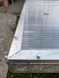 Screws and bolts secure the panels to the metal frame.