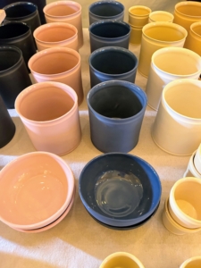 Marcie hand makes porcelain mugs, crocks, and bowls. She brought many to sell in a variety of cheerful colors.