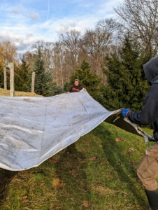 Next, to keep excess moisture from saturating the tubers, Brian and Phurba also cover the bales. They uses old tarps, also saved from another project.
