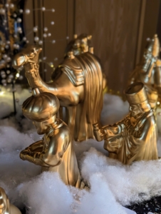 On a nearby table, wise men and a camel - just some of the figures in my Nativity Set – now in an elegant ceramic gold. It is comprised of 14-figurines in all, including three camels, two shepherds, two oxen, three wisemen, an in-keeper, Joseph, Mary, and Baby Jesus in a manger.