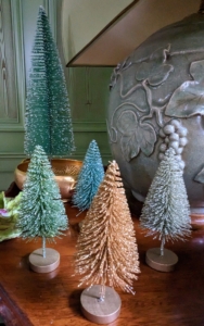 Green, silver, and copper bottle brush trees adorn the table.