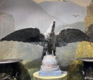 This majestic bird is part of an installation view of Barbara Israel Garden Antiques. It is an impressive zine pilot-house eagle with outspread wings. Its details show feathers that are finely articulated, with the beak slightly open, and the talons resting on a domed base. It is American, ca. 1880. Eagles were regularly used as maritime ornaments positioned on the top of a ship’s pilot house, or on a tugboat’s prow.